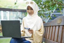 Mulher em um Hijab fazendo compras online — Fotografia de Stock
