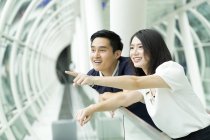 Young asian couple pointing on something — Stock Photo