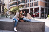 Freunde schauen auf den Straßen Madrids auf ihr Smartphone — Stockfoto