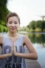 Young sporty asian woman making yoga — Stock Photo