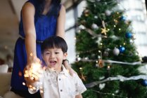 Asian family celebrating Christmas holiday with firework sparkler — Stock Photo