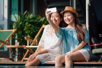 Attraente giovani asiatico donne prendere selfie vicino piscina — Foto stock