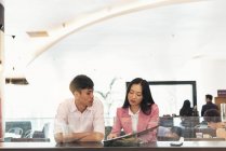 Attractive young asian couple looking at documents together — Stock Photo