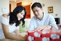 Feliz asiática familia en navidad vacaciones, hombre y mujer envoltura regalos - foto de stock