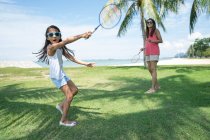Mother and daughter playing badminton on beach — Stock Photo