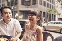 Молода щаслива азіатська сім'я, батько сміється з дівчиною — стокове фото