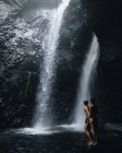 Молодая пара исследует пещеру и водопад на Бали — стоковое фото