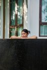 Giovane donna asiatica rilassante in una piscina — Foto stock