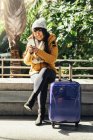 Turista donna asiatica utilizzando cellulare in stazione ferroviaria. Concetto turistico . — Foto stock