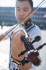 Молодий азіатський музикант чоловік зі скрипкою крупним планом — стокове фото