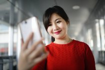 Junge schöne asiatische Frau mit Smartphone — Stockfoto
