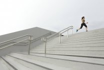 Una joven asiática, corredora femenina está subiendo una escalera en Singapur
. - foto de stock