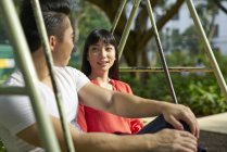 Young asian casual couple on swing together — Stock Photo