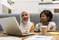 Young multicultural business women working with laptop in modern office — Stock Photo