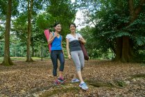 Two women walking to their Yoga location in Botanic gardens, Singapore — Stock Photo