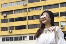 Молода випадкова азіатська дівчина в сонцезахисних окулярах позує на камеру — стокове фото
