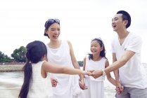 Щаслива азіатська сім'я проводить час разом на пляжі — стокове фото