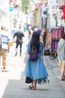 Приваблива азіатська жінка, що йде по міській вулиці, вид ззаду — стокове фото