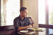 Jovem asiático bonito homem no café com vinho — Fotografia de Stock