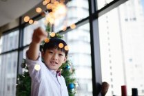 Asiatique famille célébrant Noël vacances, garçon avec feu d'artifice scintillant — Photo de stock