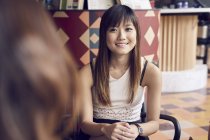 Junge süße asiatische Frau sitzt auf Stuhl — Stockfoto