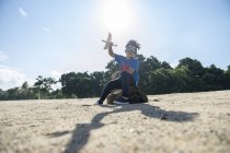 Superhéroe niño jugando con un avión de juguete - foto de stock