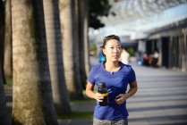 Jeune sportive asiatique femme courir à parc — Photo de stock