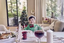 Felice giovane asiatico ragazzo celebrando il Natale a tavola — Foto stock