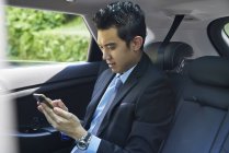 Молодий чоловік бізнесмен перевіряє свій мобільний — стокове фото