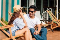 Attractive young asian couple relaxing near pool — Stock Photo
