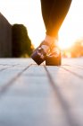 Füße mit modischen Sandalen, auf der Straße bei Sonnenuntergang natürliches Licht — Stockfoto