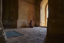 Молодий леді відпочиває всередині стародавнього храму, Pagoda, Баган, М'янма — стокове фото