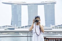 Дівчинка стріляє у фотоапарат на Рафлз Плейс (Сінгапур). — стокове фото