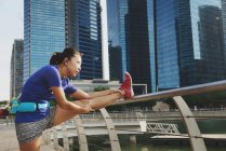 Junge asiatische sportliche Frau macht Stretching im Freien — Stockfoto