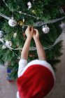 Asian family celebrating Christmas holiday, boy decorating fir tree — Stock Photo