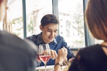 Compagnie de jeunes amis asiatiques manger dans le café — Photo de stock
