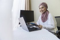 Donna d'affari musulmana che lavora su laptop da casa . — Foto stock