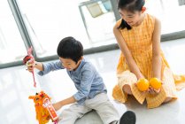 Asiático irmão e irmã brincando com brinquedos — Fotografia de Stock
