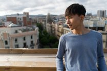 Junger chinesischer Mann schaut von der Kamera weg — Stockfoto