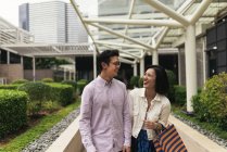 Giovane casuale asiatico coppia con borse a shopping in centro commerciale — Foto stock