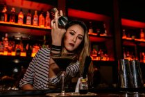 Портрет молодої жінки-бармена, що робить коктейль в барі — стокове фото