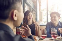 Company of young asian friends together in restaurant — Stock Photo