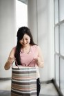 Молода красива азіатська жінка з сумкою — стокове фото