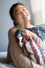 Junge attraktive asiatische Frau mit amerikanischen Flagge Kissen — Stockfoto
