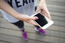 Sportliche Frau nutzt Smartphone im Freien — Stockfoto