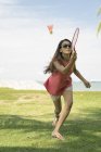 Ásia mulher jogar badminton no o praia . — Fotografia de Stock