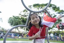 Retrato do garoto cingapuriano orgulhoso com bandeira nacional — Fotografia de Stock