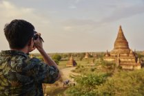 Giovane uomo che scatta foto intorno all'antico tempio di Pyathadar, Bagan, Myanmar — Foto stock