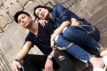 Belle jeune asiatique couple assis sur marches — Photo de stock