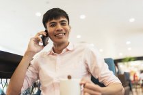 Attractive young asian man using smartphone — Stock Photo
